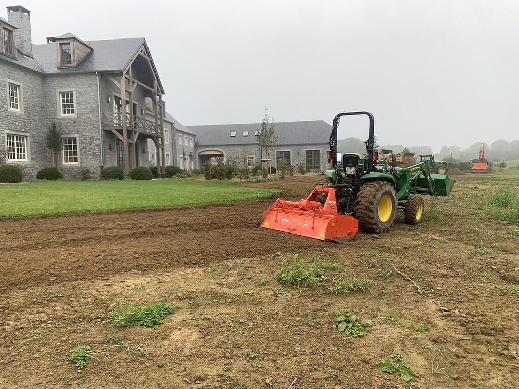 Préparation mécanique du terrain pour la création d’une pelouse avec tracteur John Deere