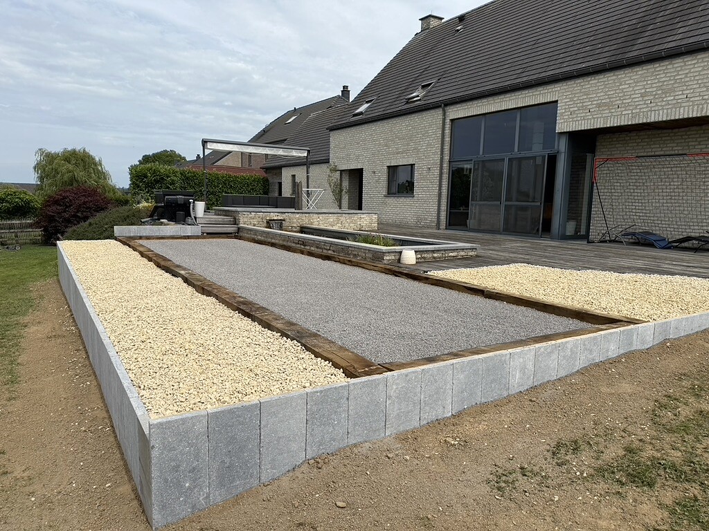 Terrain de pétanque terminé avec bordures, traverses en bois et zones décoratives en gravier
